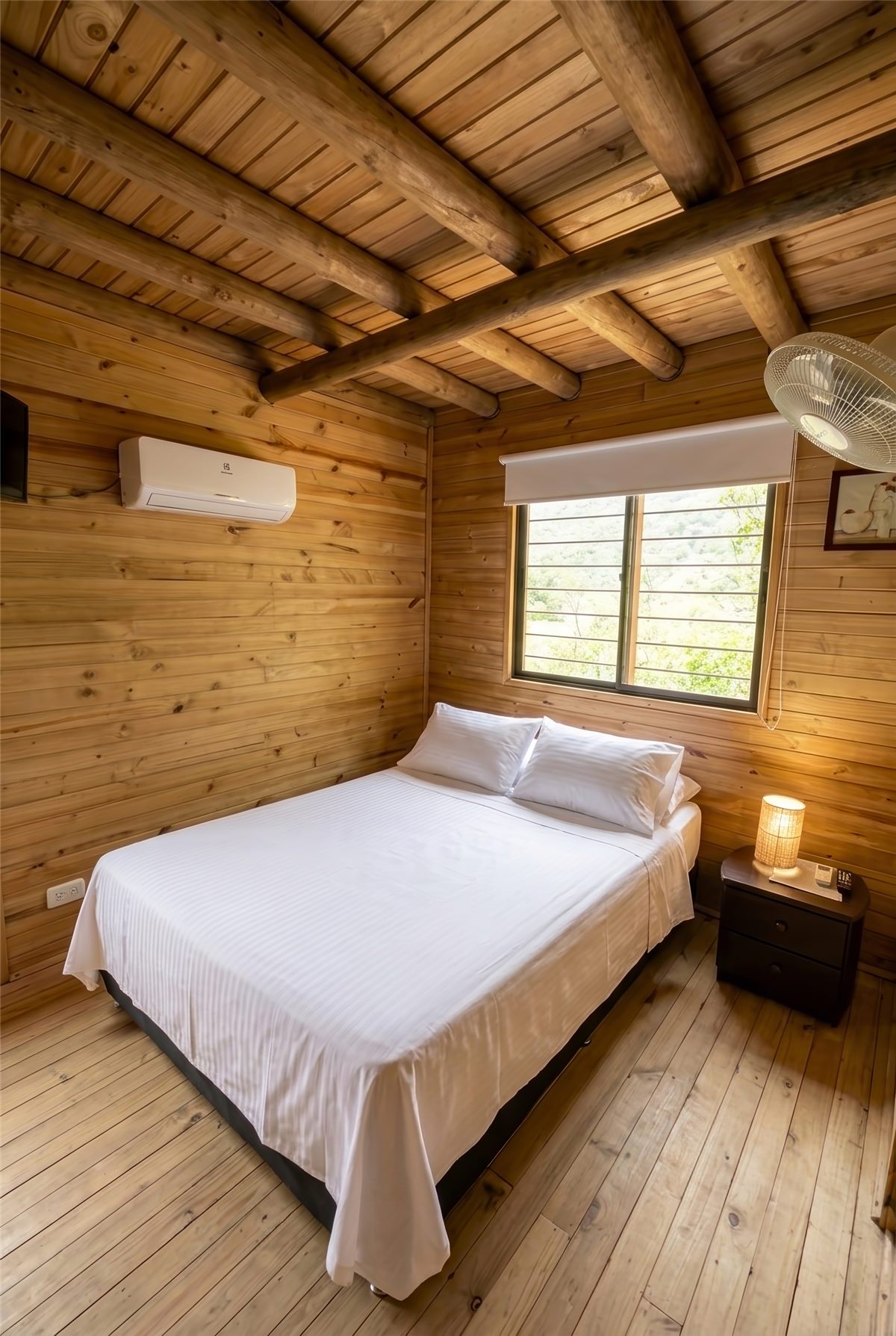 Habitación con aire acondicionado: paredes y techo en madera, cama doble y ventilador de techo