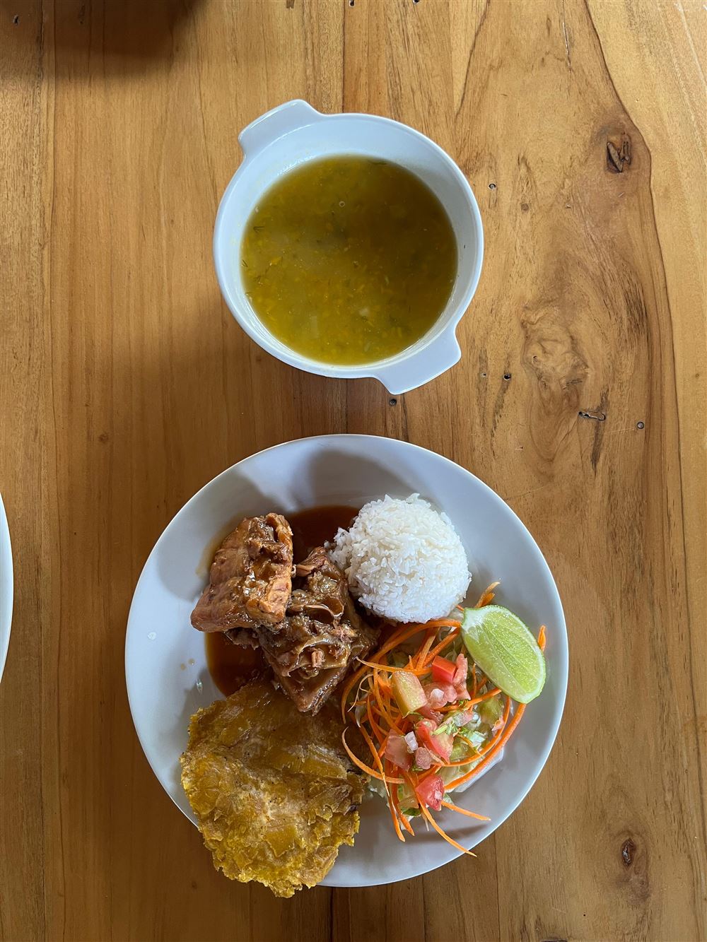 Sopa, carne en salsa, arroz, patacón y ensalada vistos desde arriba